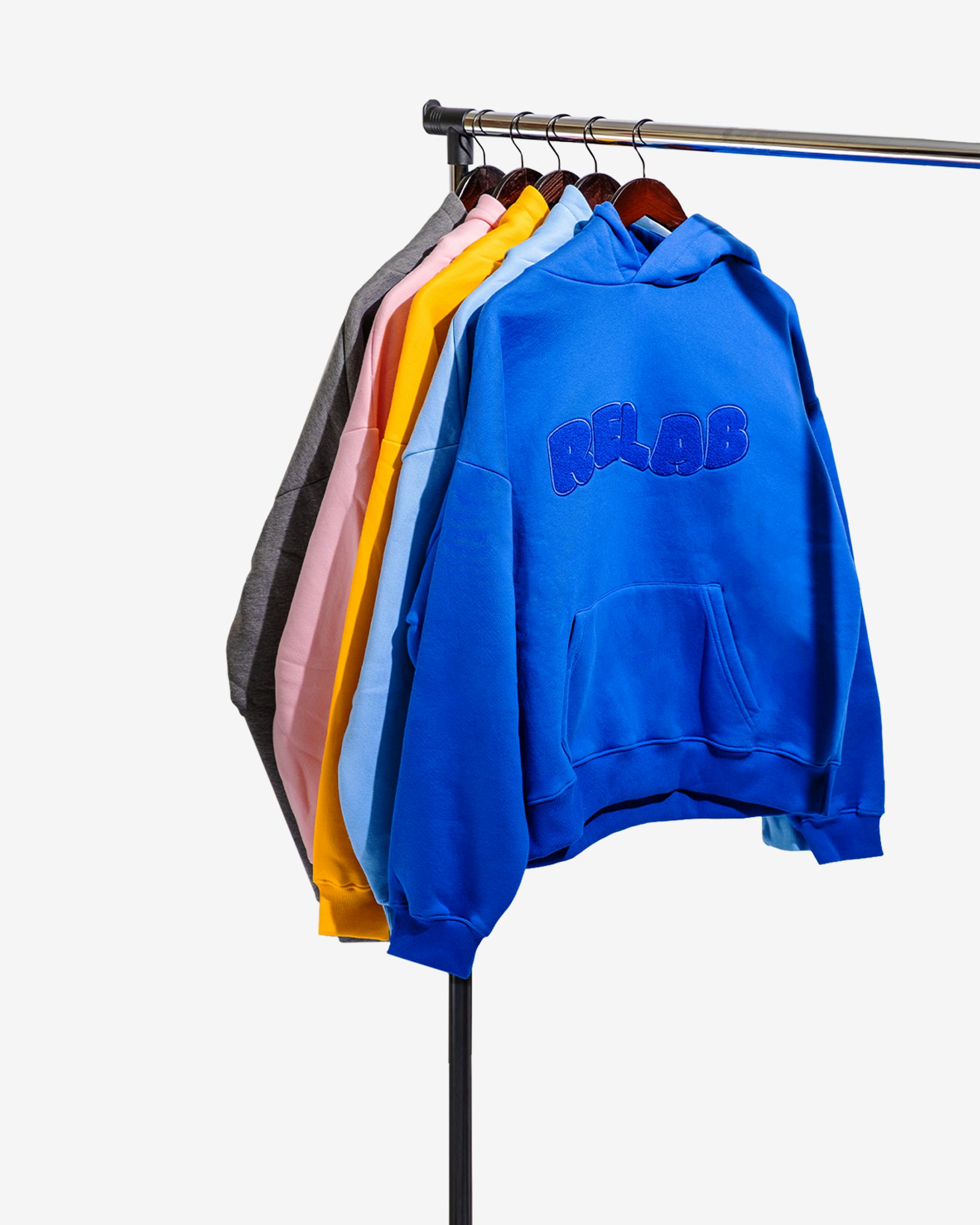 Vibrant hoodies hanging in a studio, showcasing fashion diversity.