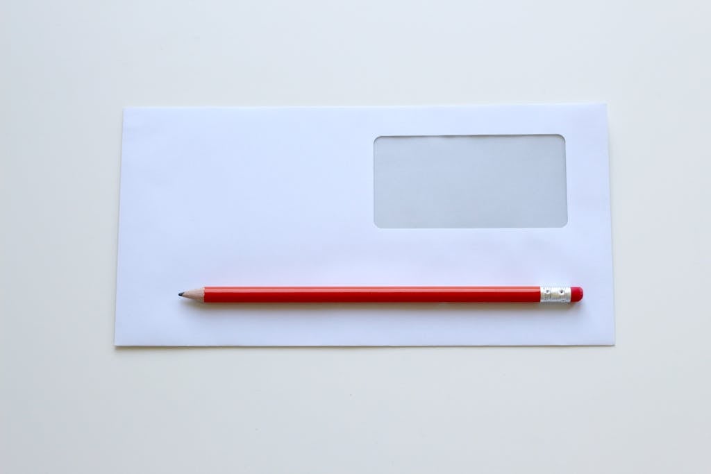 Red Pencil on Top of White Window Envelope